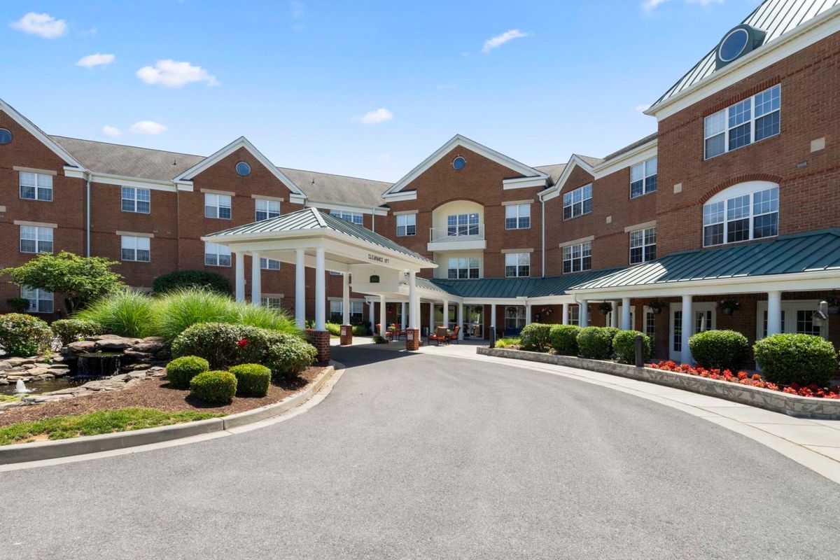 A large residential building with a landscaped entrance and driveway.