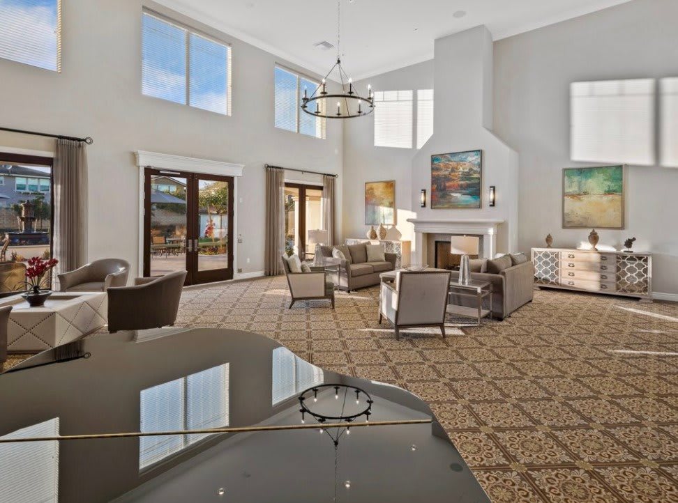 A spacious and modern living room with elegant furniture, a fireplace, and a grand piano.