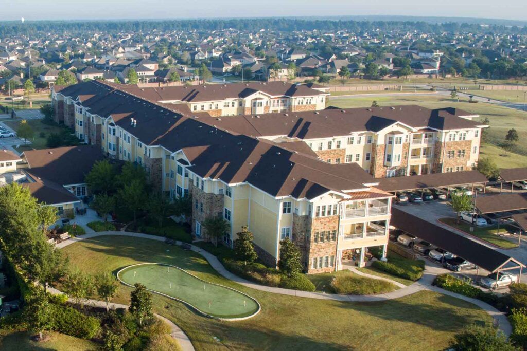 Aerial view of a residential apartment complex in a suburban area with landscaped surroundings.
