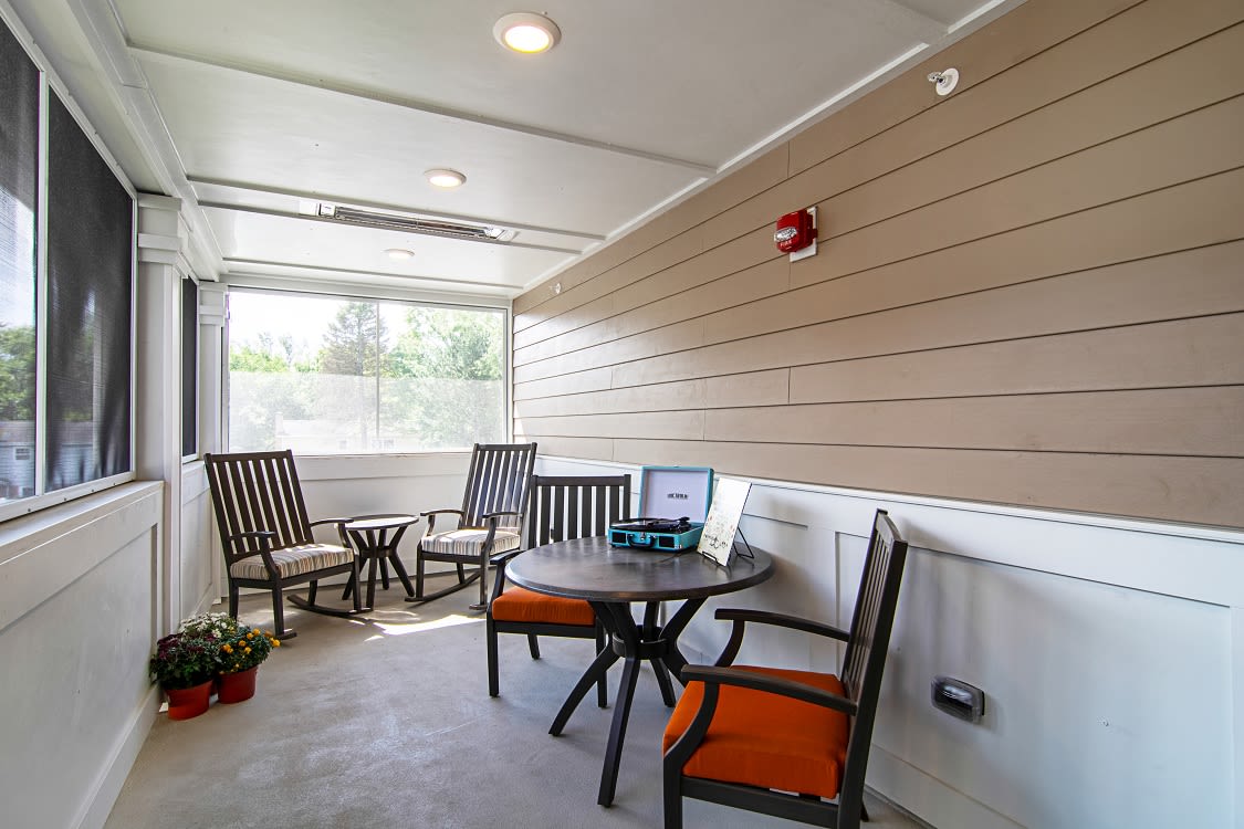 A cozy indoor patio with comfortable seating and a table, ideal for relaxing or working.