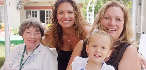 A smiling family group photo taken outdoors.