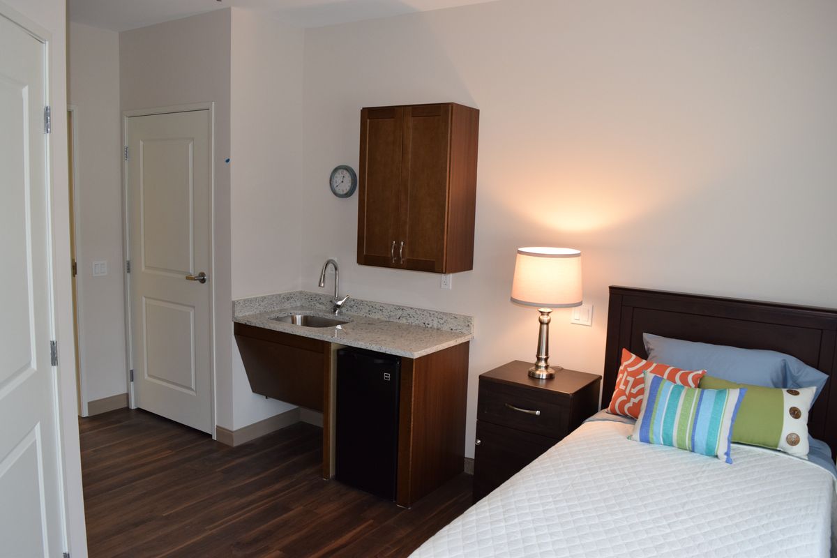 A cozy bedroom with a small kitchenette and modern decor.