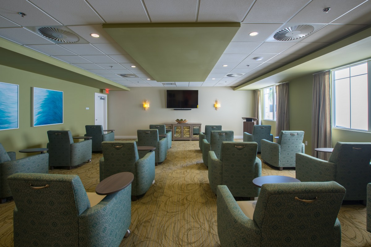 A modern lounge area with multiple chairs and a large television.