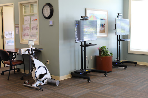A glimpse into a fitness area featuring a stationary bike and monitor stands, designed for exercise and rehabilitation.