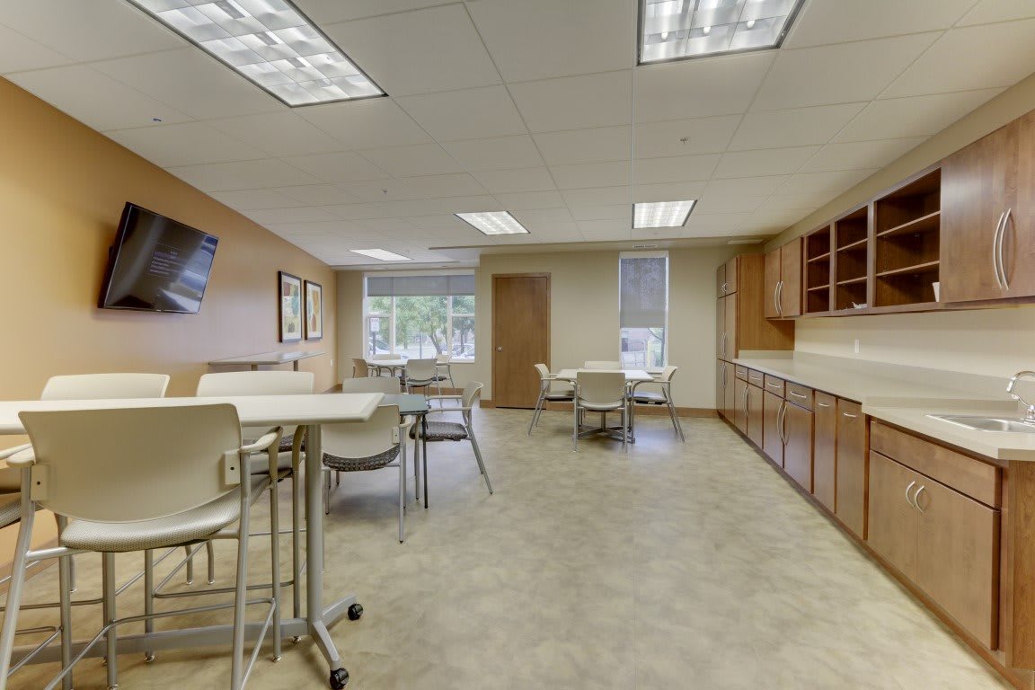 Modern office meeting room with tables and chairs.
