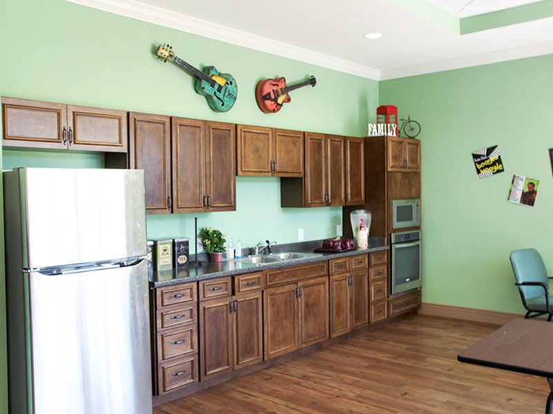 A kitchen with wooden cabinets and guitars as wall decor.