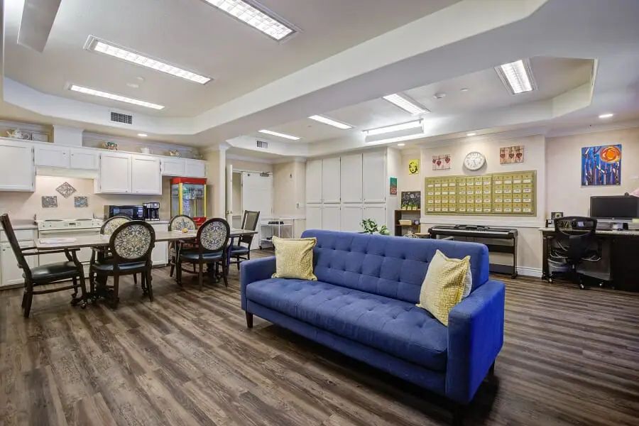 A modern and cozy living space with a blue sofa and dining area.