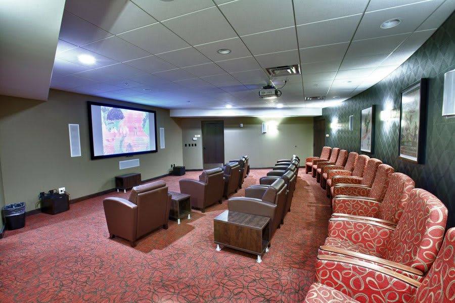 A modern home theater with comfortable seating, a large screen, and a projector.