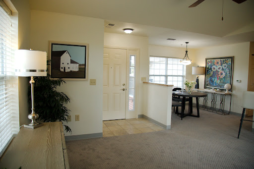 A cozy entrance to a well-lit living space featuring a dining area and artwork on the walls.