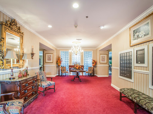 An elegant lobby featuring luxurious furnishings and a vibrant red carpet.