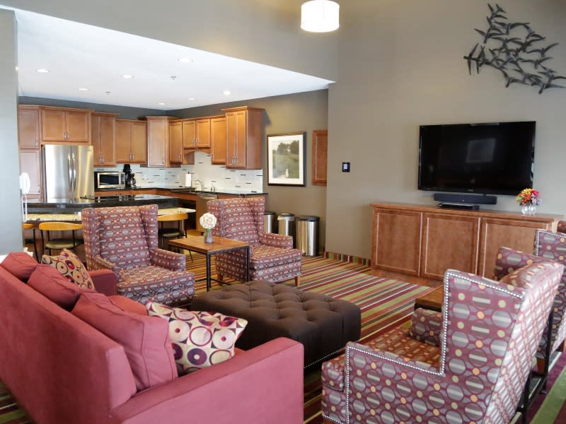 A cozy open-plan living room and kitchen area with comfortable seating and a large television.