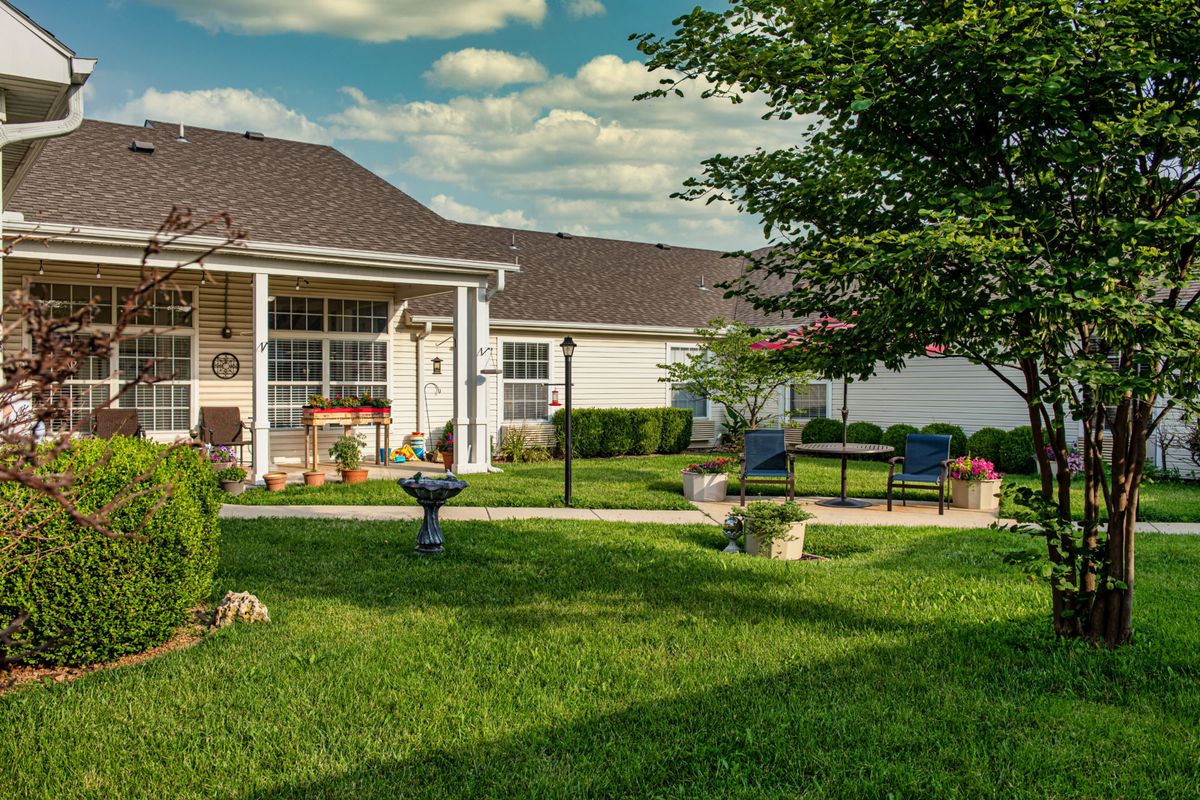A cozy backyard with a patio, seating area, and well-maintained lawn.