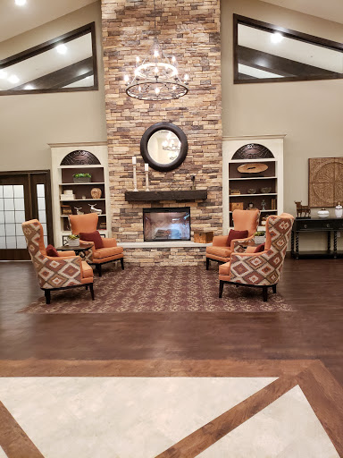 A cozy living room featuring a stone fireplace and stylish seating arrangements.