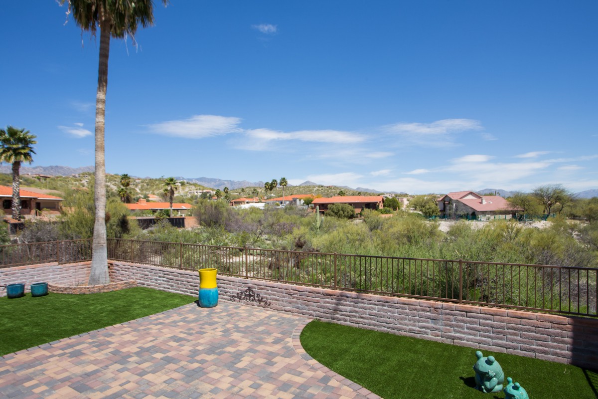 A serene suburban backyard with a view of the surrounding landscape and blue sky.
