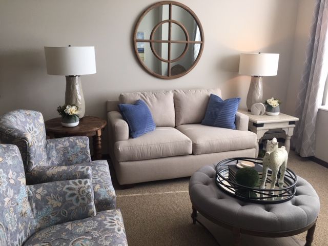 A cozy living room with a neutral-toned sofa, blue accent pillows, and elegant decor.