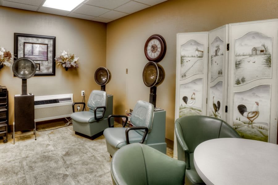 A cozy salon interior with vintage-style chairs and hair dryers.