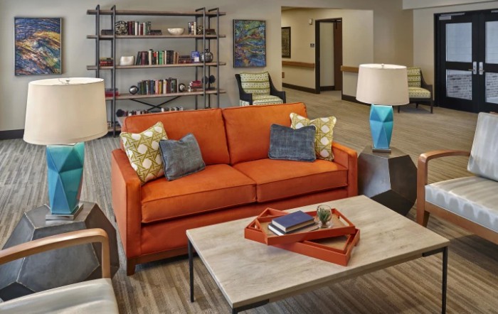 A modern living room with an orange sofa and stylish decor.