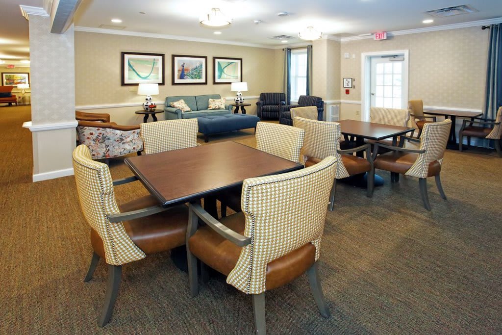 A cozy dining area with several tables and chairs, well-lit and inviting for gatherings.