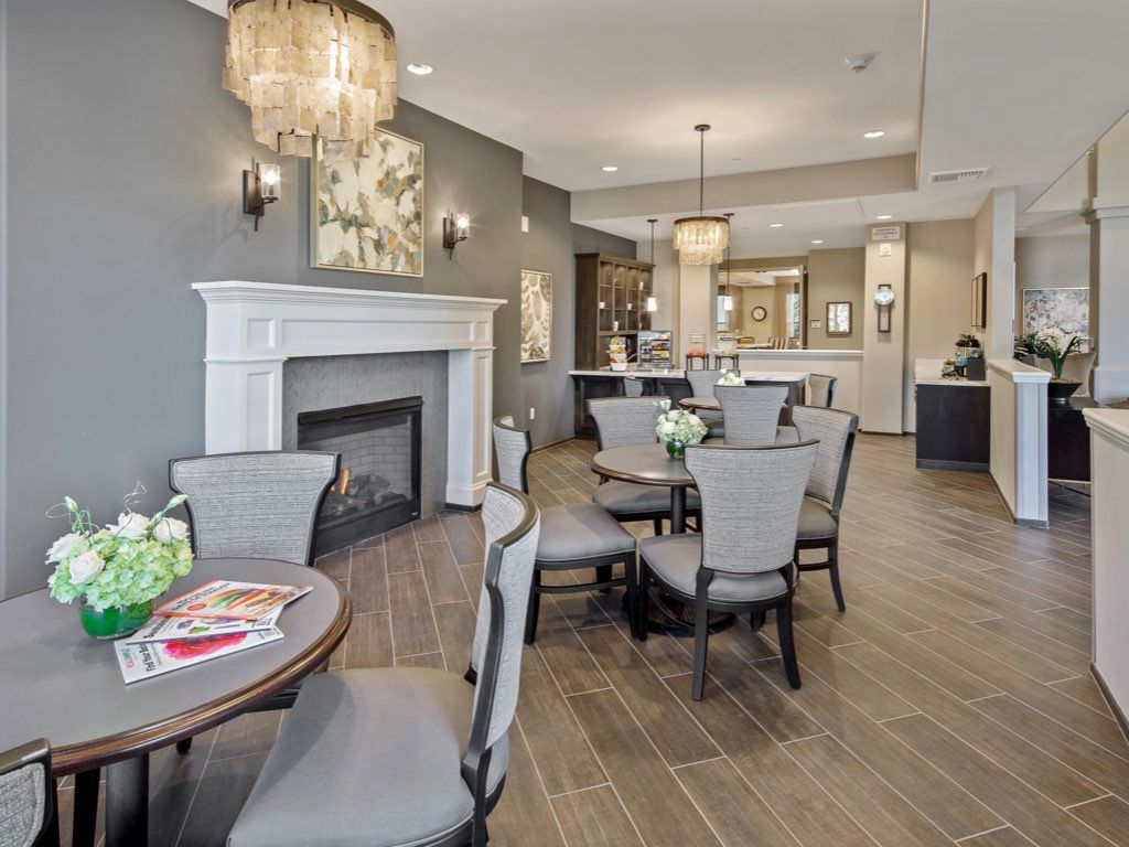 A modern lounge area featuring elegant chandeliers, comfortable seating, and a cozy fireplace.