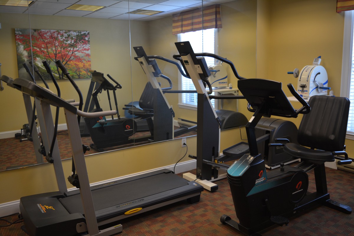 A small gym room featuring treadmills and elliptical machines.