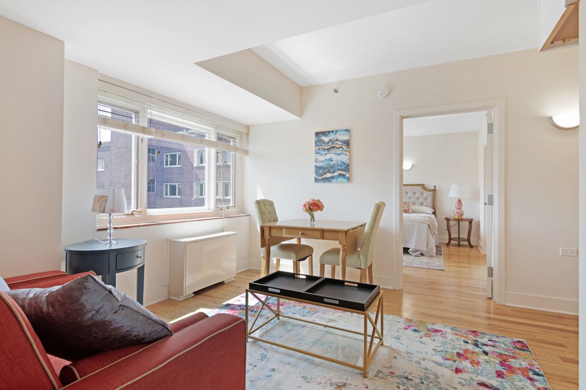 A bright and cozy apartment interior featuring a living room and dining area with natural light.