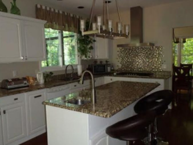 Modern kitchen with a central island and elegant granite countertops.