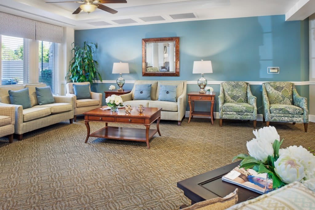 A well-decorated living room featuring comfortable sofas, a wooden coffee table, and elegant lighting.
