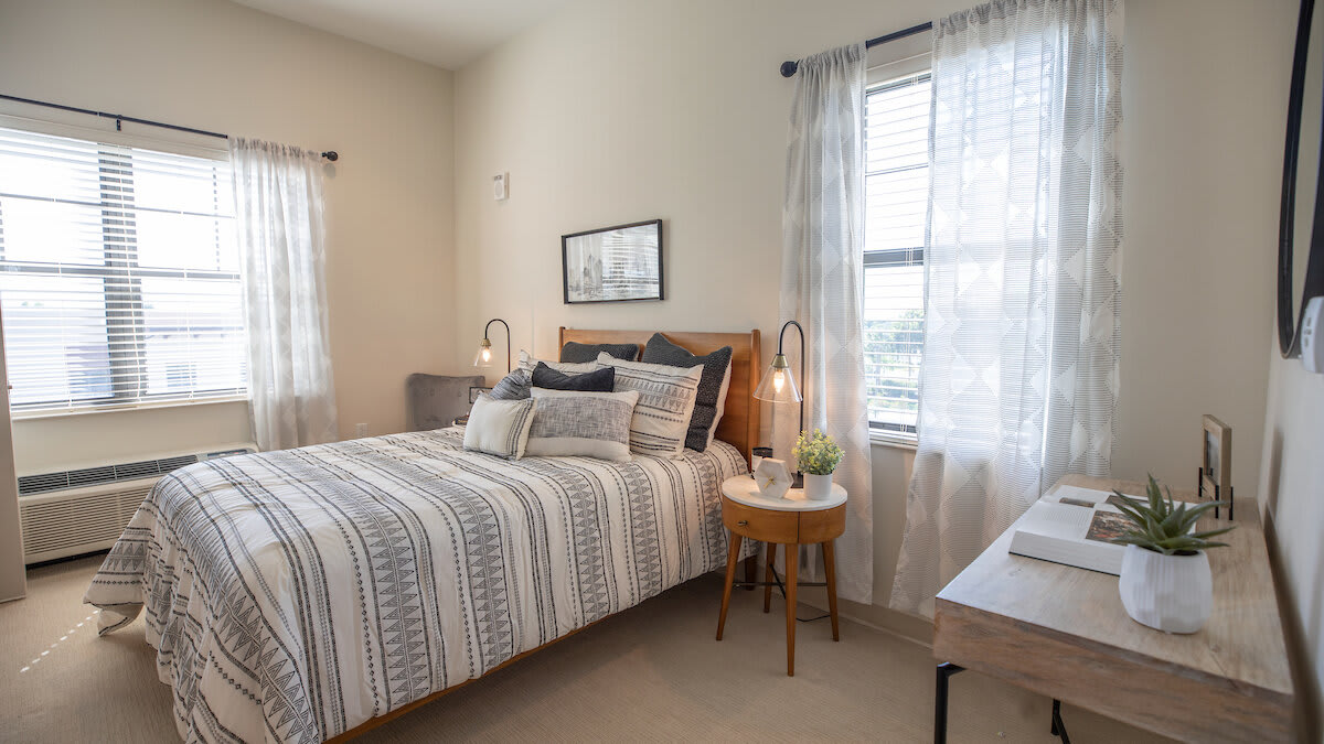 A cozy bedroom with a neatly made bed, soft lighting, and elegant decor.