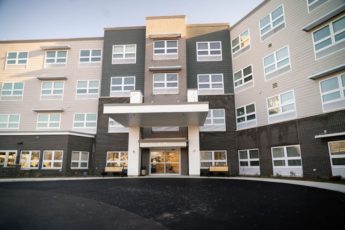 A modern multi-story apartment building with a central entrance.