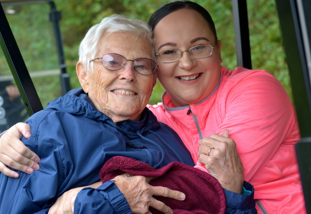Two women smiling and enjoying time together outdoors.