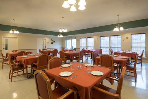 A spacious dining room setup with neatly arranged tables and chairs, ready for a meal.