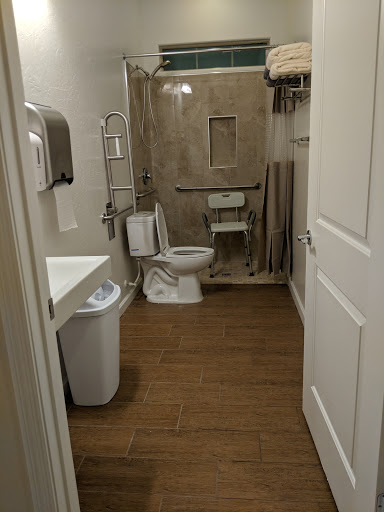 A modern bathroom featuring essential facilities including a toilet, sink, and a shower area.