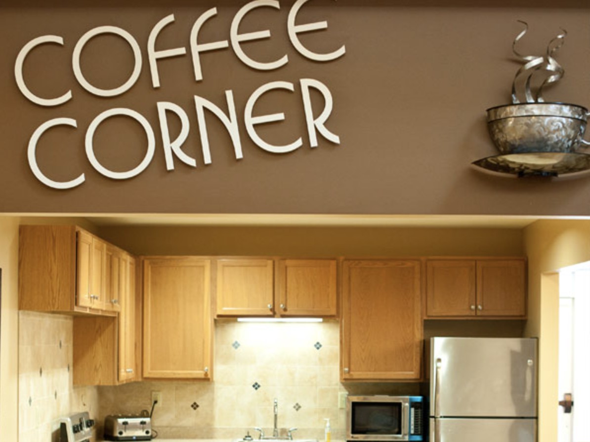 A cozy kitchen area labeled 'Coffee Corner' with wooden cabinets and modern appliances.