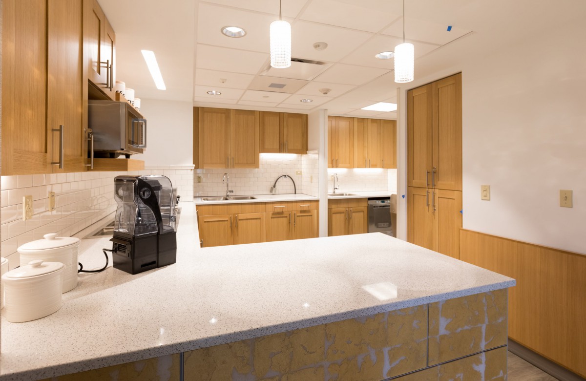 A modern kitchen with sleek countertops, wooden cabinets, and stylish lighting.