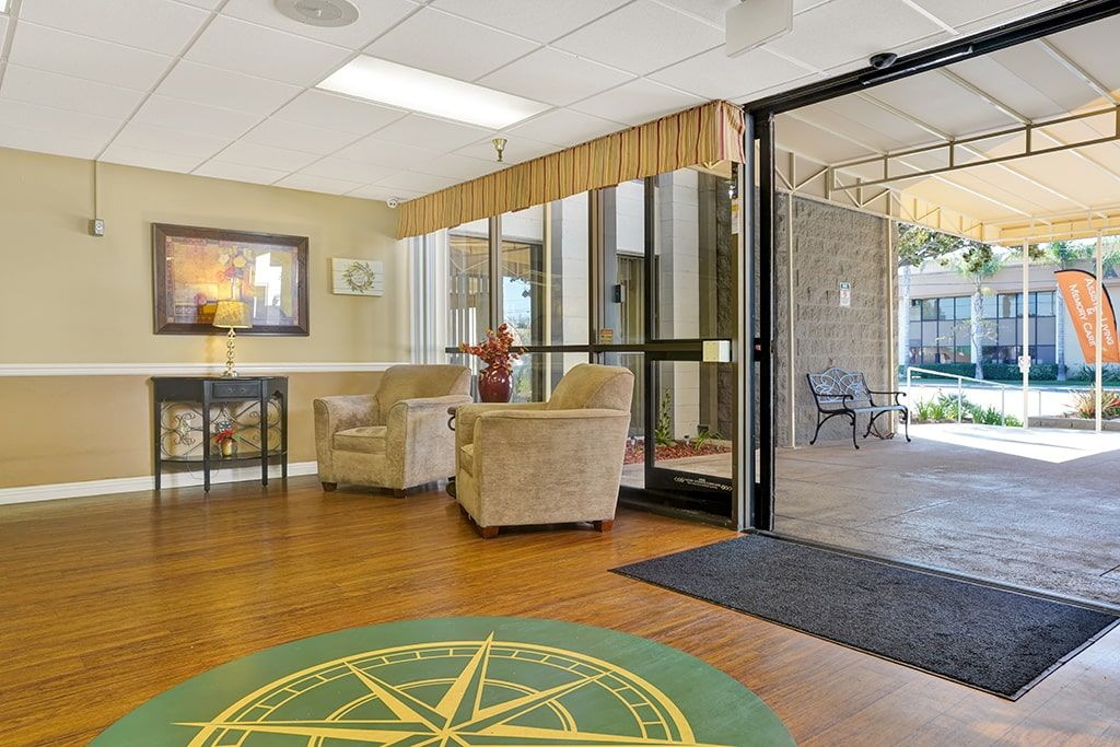 A cozy lobby area with comfortable chairs and large glass doors inviting natural light.