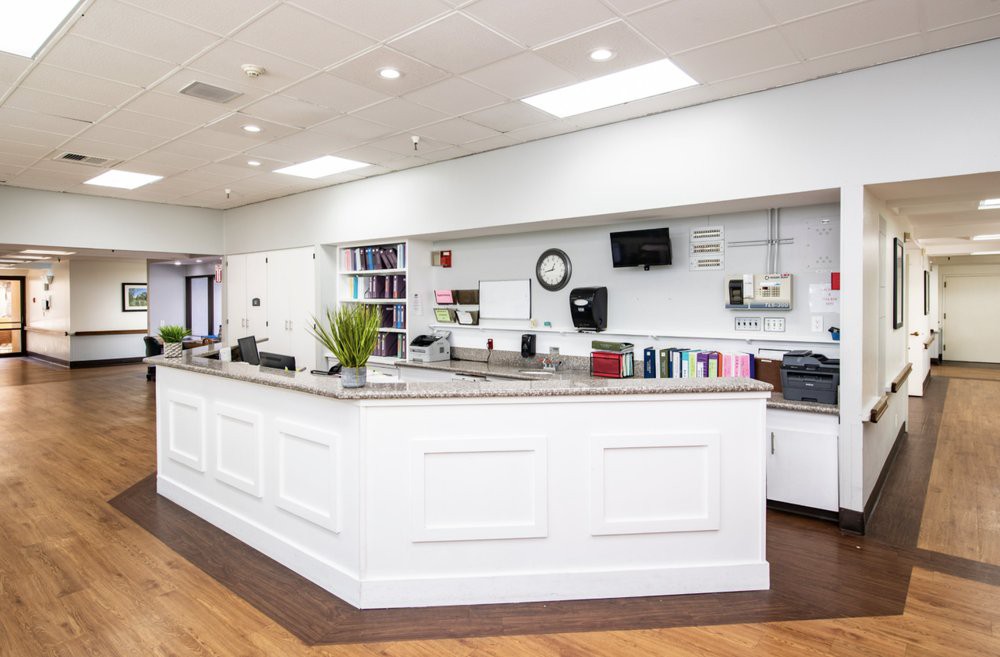 Modern reception area with a large white counter and office supplies.