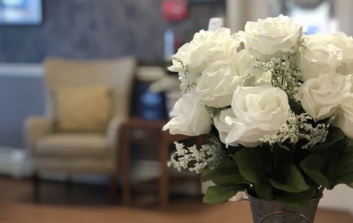 A bouquet of white roses elegantly decorates a cozy living space.