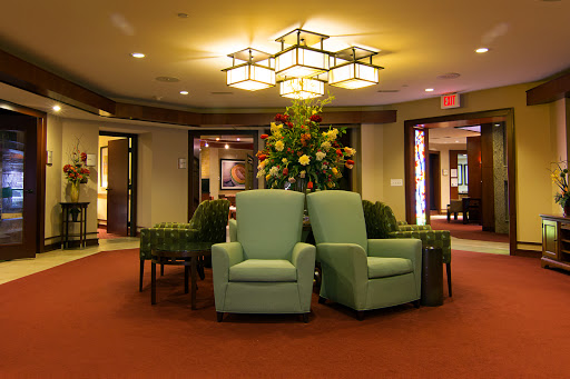A cozy lobby area featuring comfortable chairs, elegant lighting, and decorative floral arrangements.