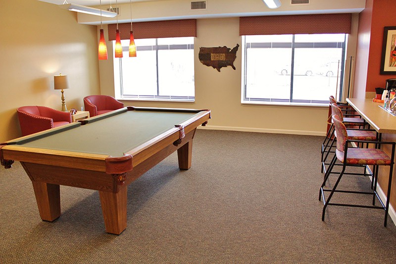 A cozy game room featuring a pool table and comfortable seating.