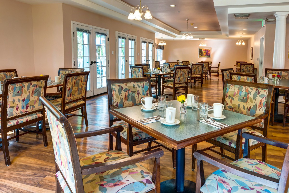 An empty dining area with neatly arranged tables and chairs, ready for guests.