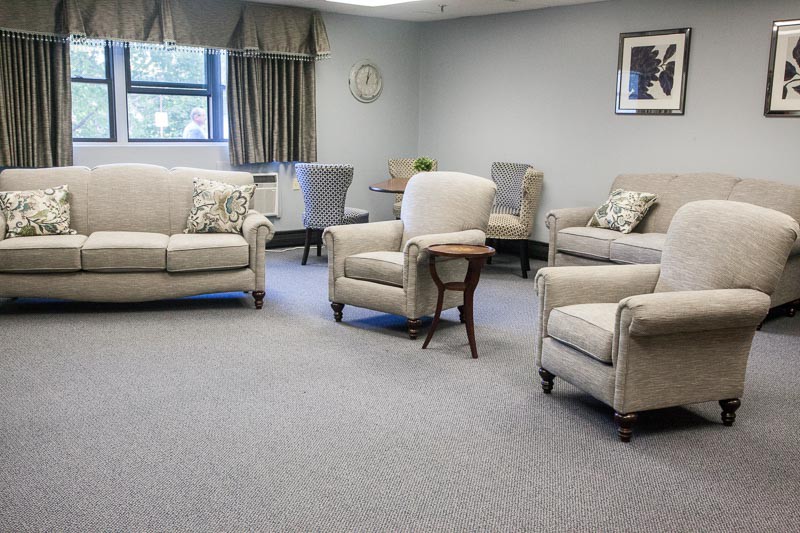 A cozy living room with comfortable chairs and a sofa arranged around a small table.
