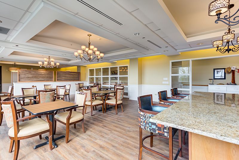 A spacious dining area with elegant furnishings and chandeliers.