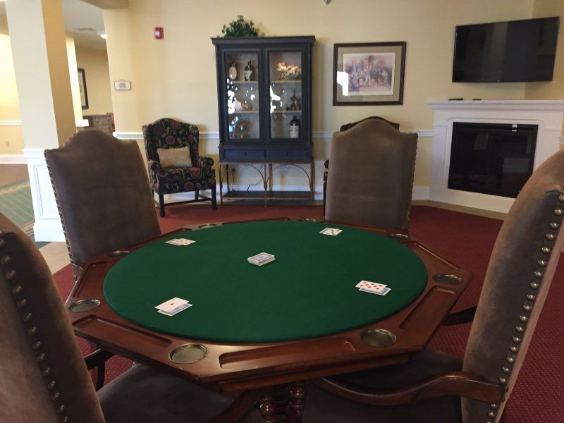 A poker table with playing cards set up in a cozy game room.