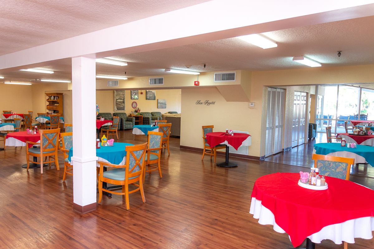 A cozy dining area with neatly arranged tables and chairs, adorned with colorful tablecloths.