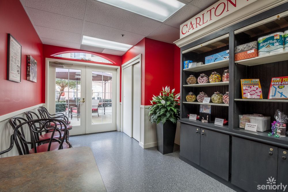 A bright store interior with red walls, displaying products on shelves and a seating area near the entrance.