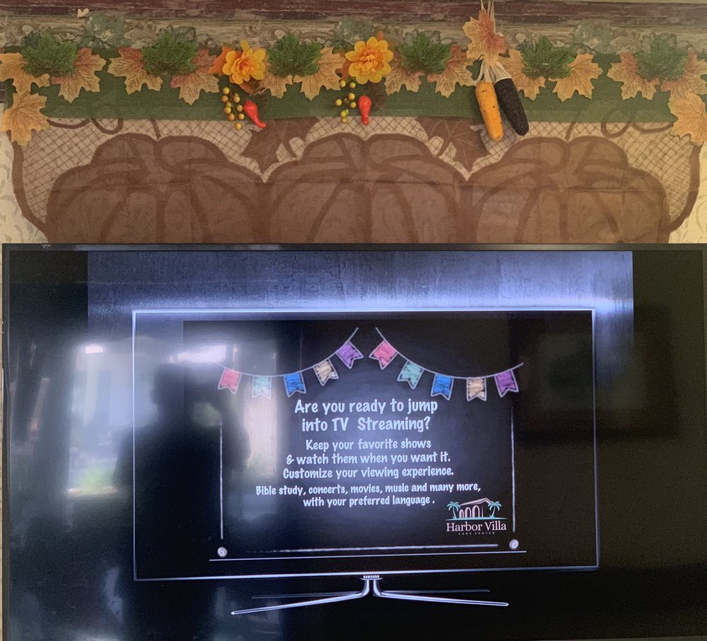 A television screen displaying a setup message in a cozy living room with decorative items above.