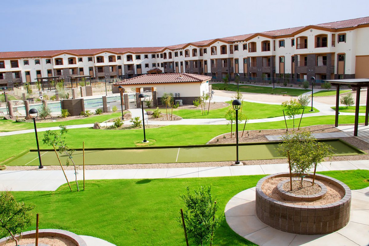 A modern residential complex surrounded by well-maintained green spaces and pathways.