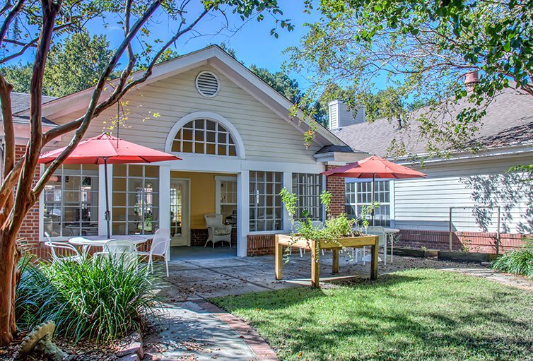 A beautiful backyard view with patio, garden, and sunshades.