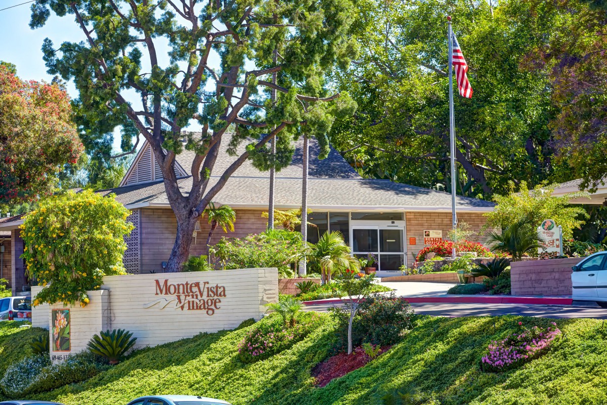 A residential building with a well-maintained garden and an American flag flying nearby.