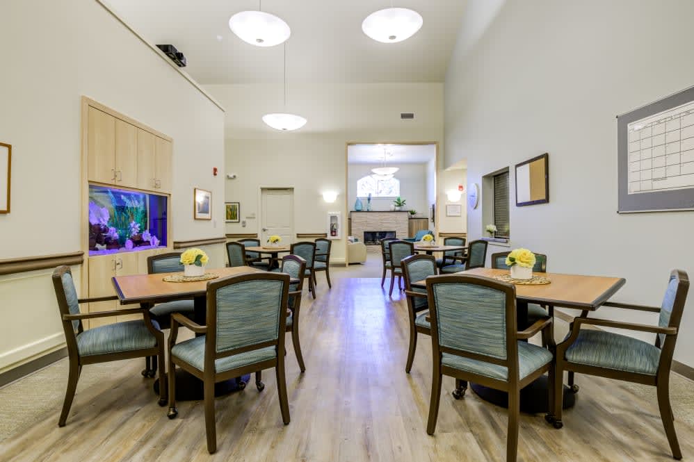 A bright and modern dining area with multiple tables and chairs, creating a welcoming community space.